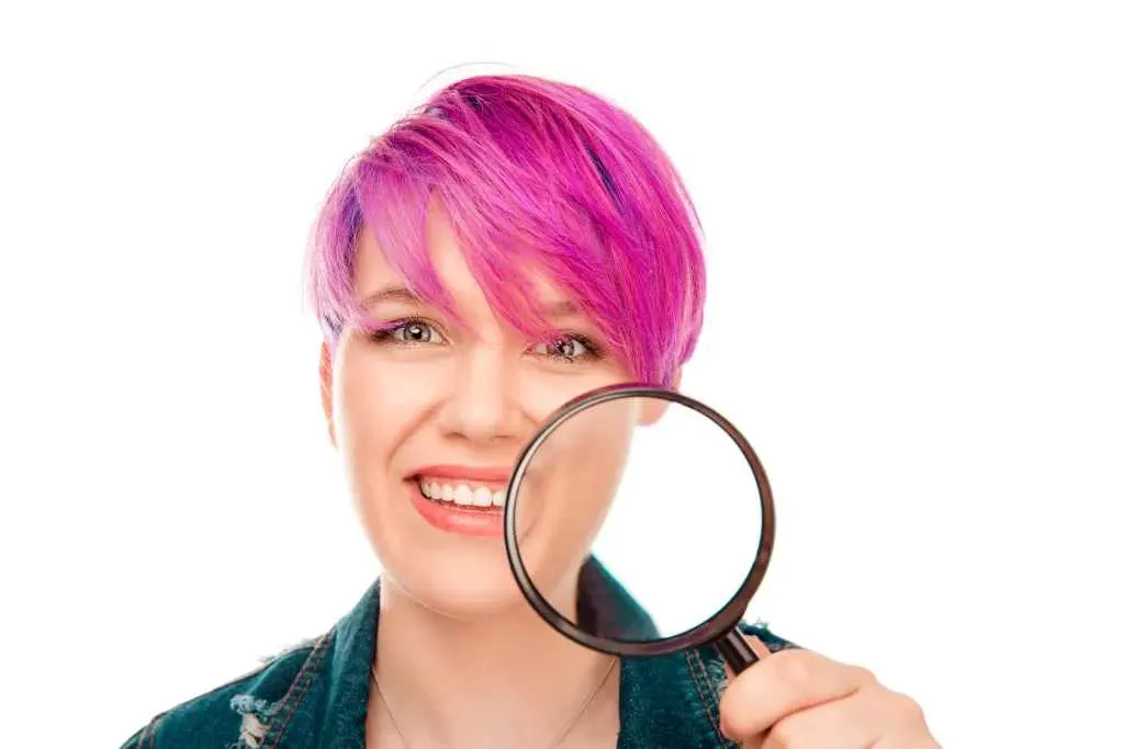 woman looking through magnifying glass